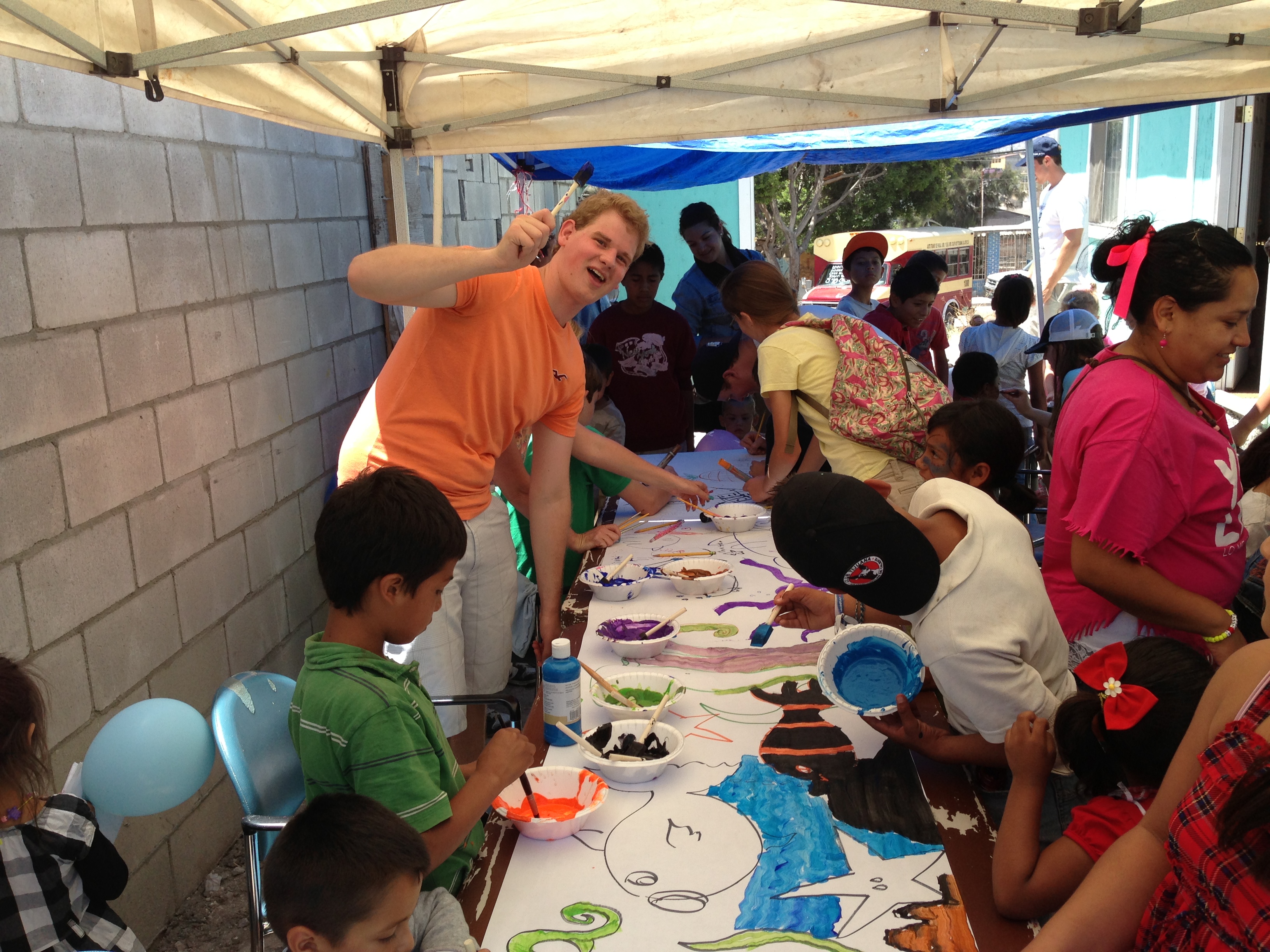 Jonathan having some fun helping the children paint a mural