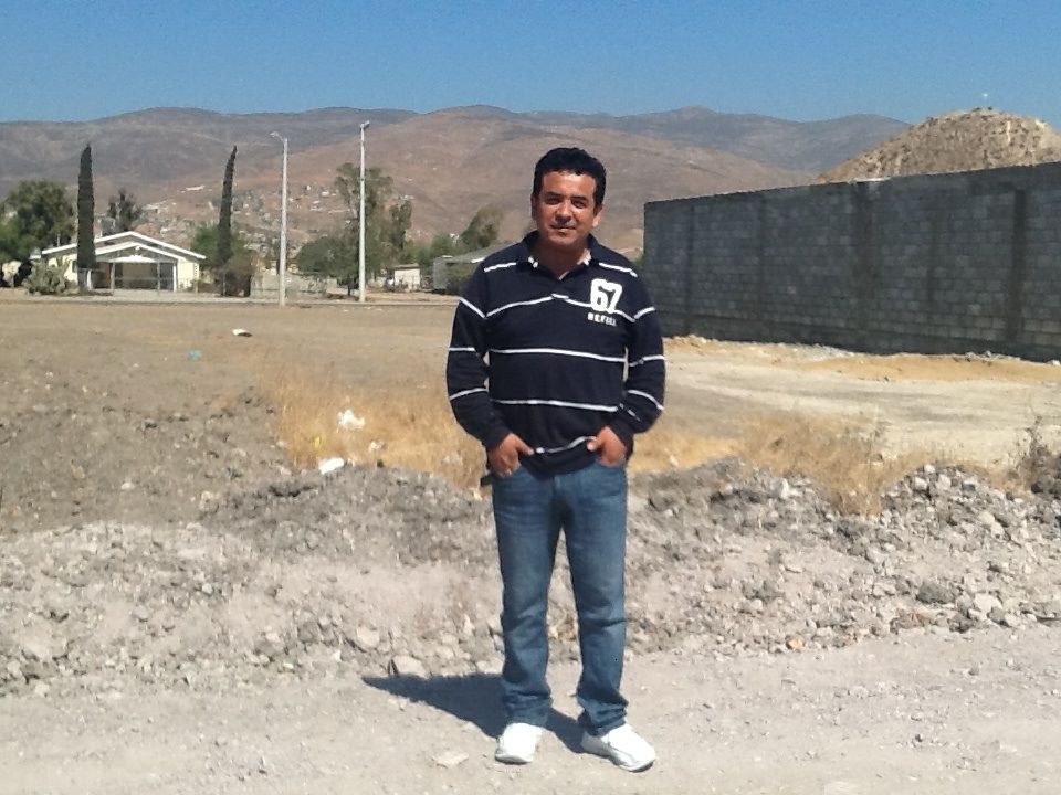 Pastor Ivan Casados with the land for the new church site behind him