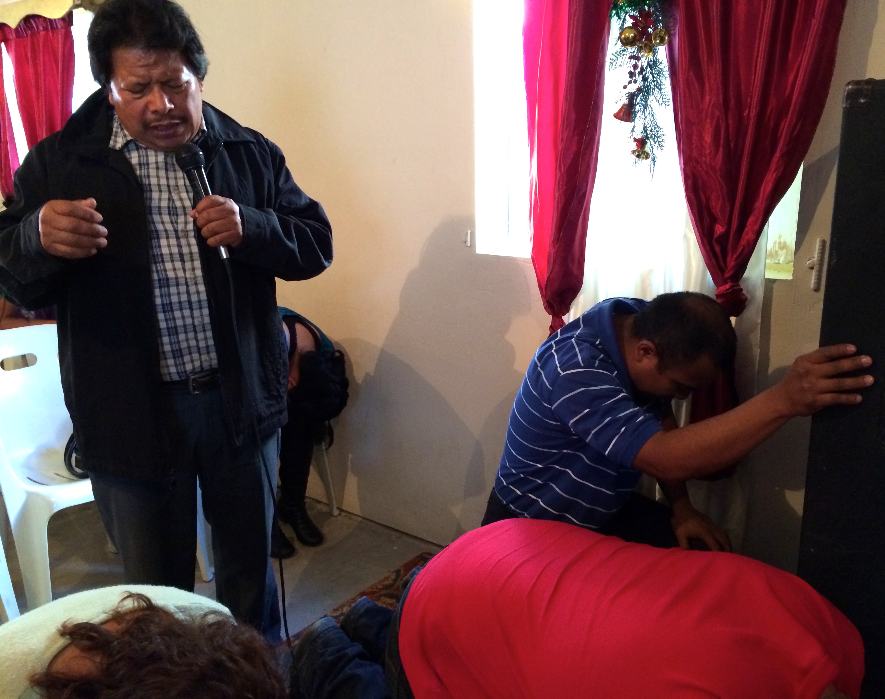 Pastor Eleodoro Rosas praying for those that came up for prayer after the sermon