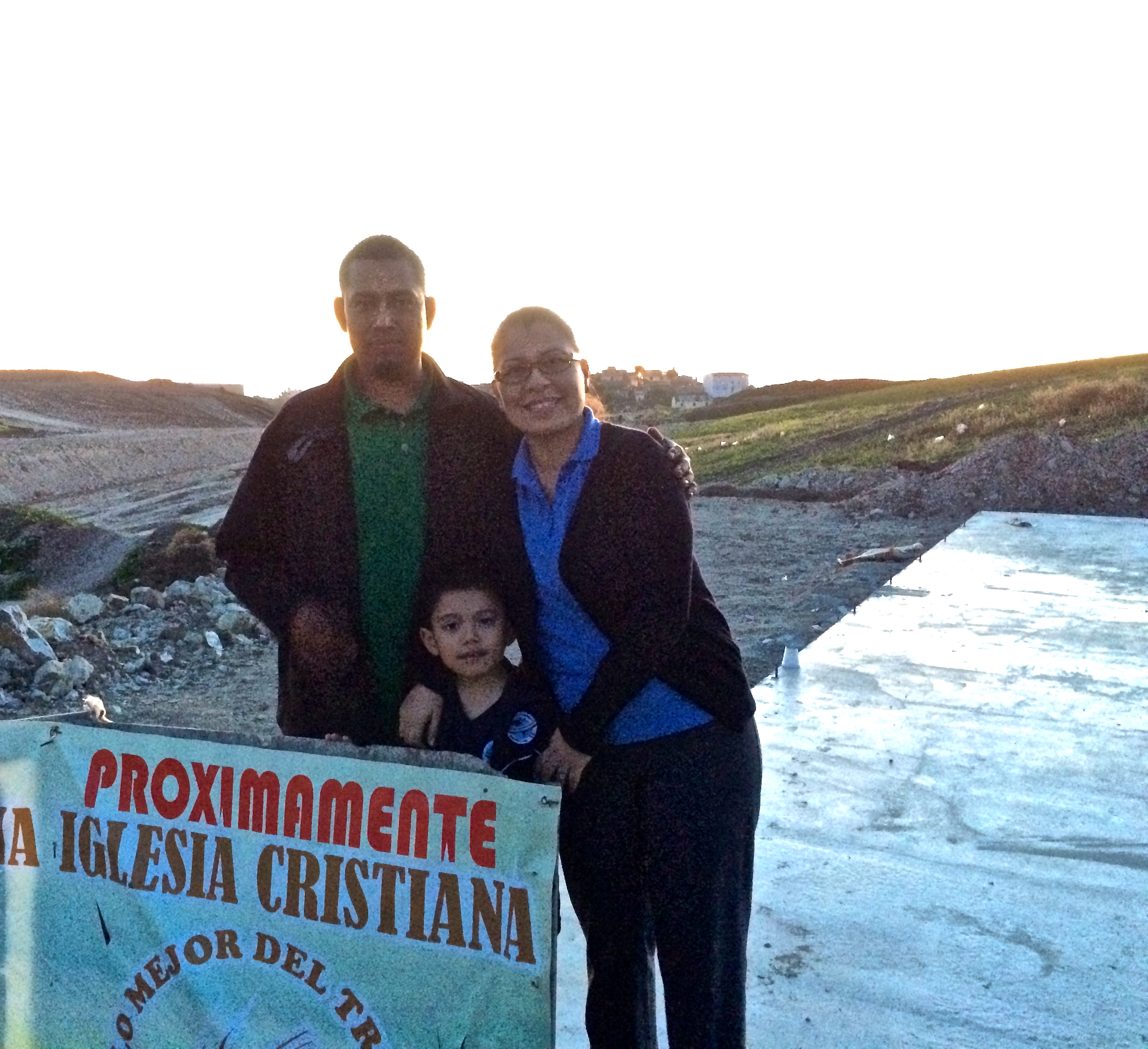 Victor and Sol with their son on the church property