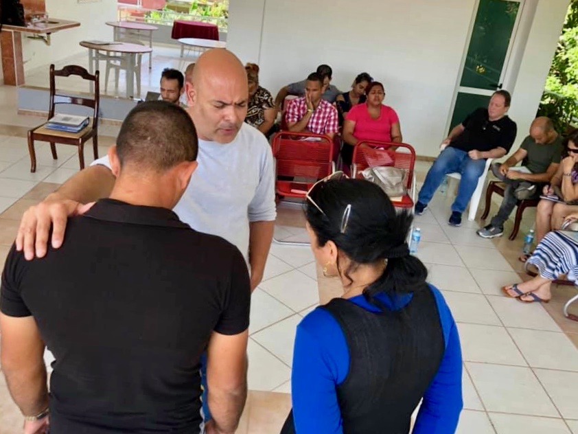 Pastor Ivan praying for church planters Osmeiki and Yosiet