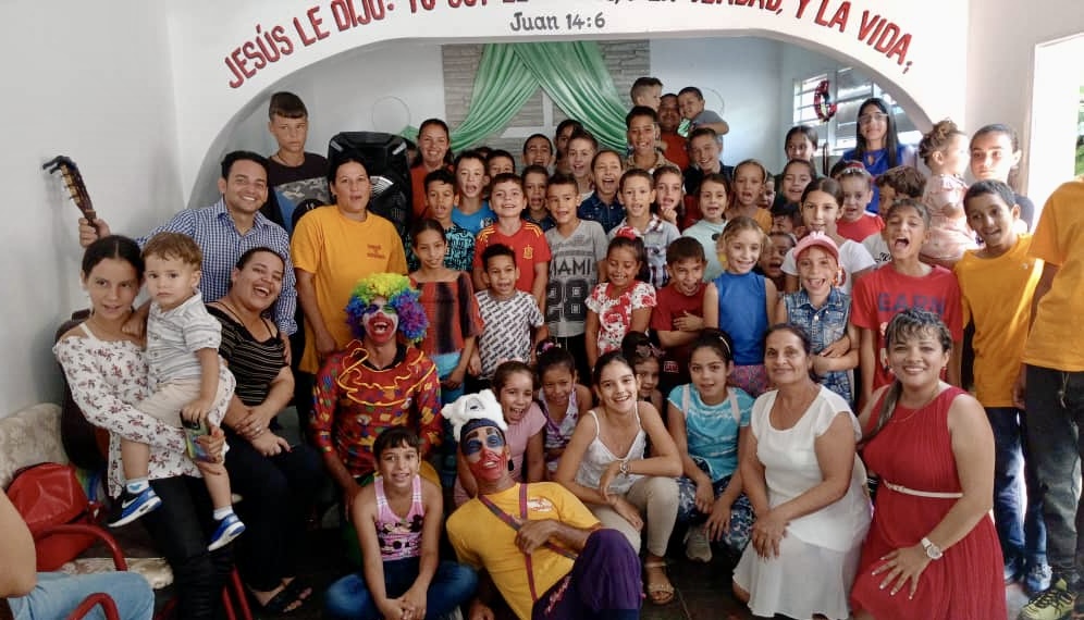 Yaima in the red dress on the right side of the photo, with some of the children that they minister to.