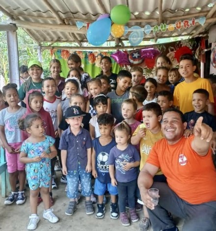 Happy faces of thankful children receiving a toy and the message of the Gospel.