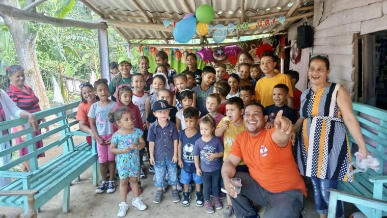 Happy faces of thankful children receiving a toy and the message of the Gospel.