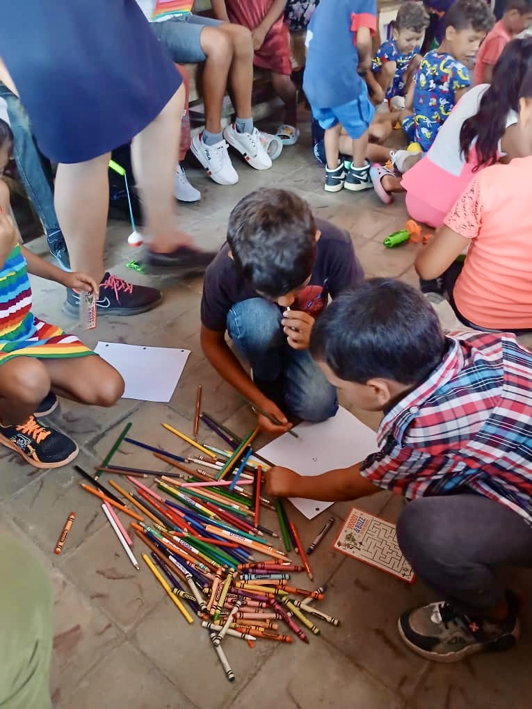 Children playing while they receive their gifts and the Gospel.