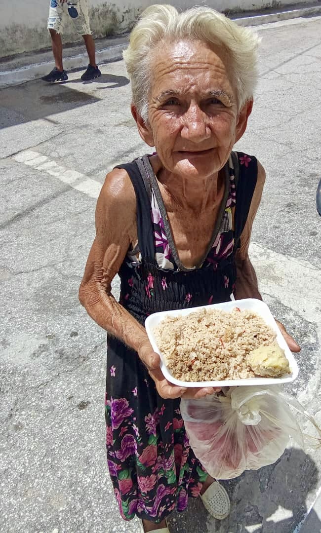 Helping an elderly woman with food aid.