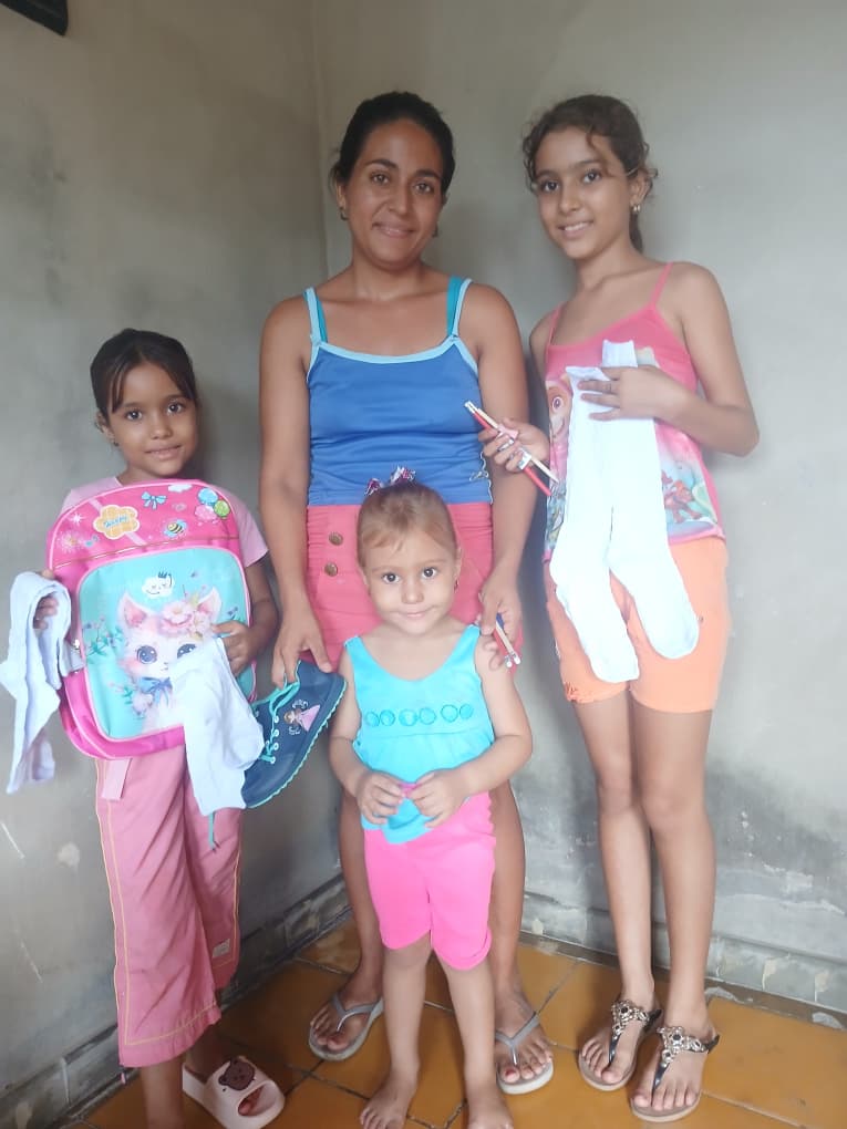 Children receiving school supplies and shoes from Hannah's Toys of Hope.