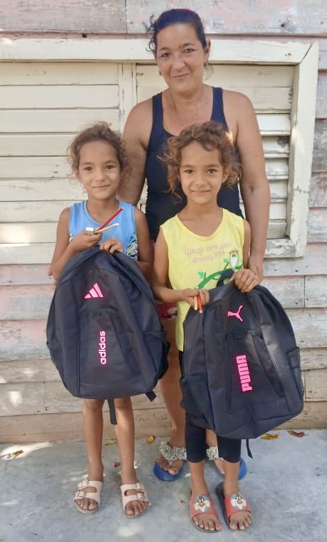 Joyful girls enjoying their new backpacks from Hannah’s Toys of Hope