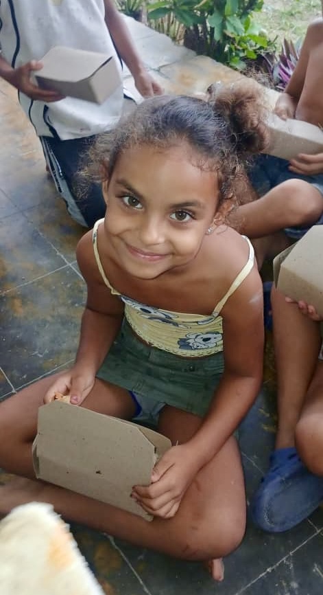 A simple meal brings smiles to this young girl.